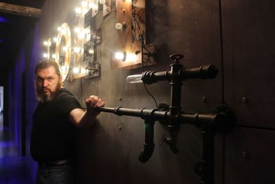 Man standing against illuminated wall