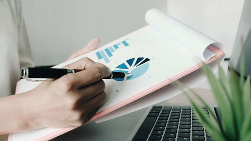 Midsection of man using laptop on table