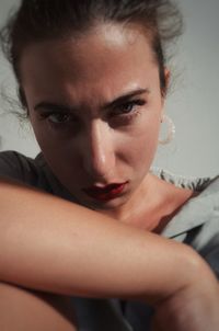 Portrait of young woman against wall