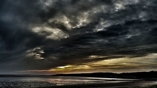 Scenic view of beach against sky at dusk