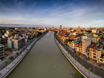 High angle view of river amidst buildings in city against sky