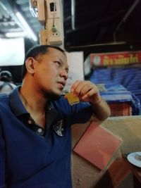 Full length of young man drinking glass at restaurant