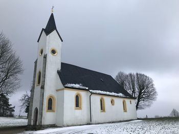 Traditional windmill against sky during winter