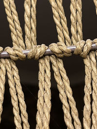 Close-up of rope tied to metal against black background