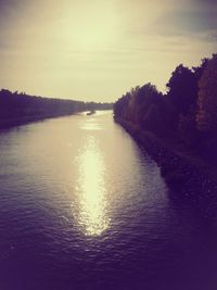 Scenic view of river against sky at sunset