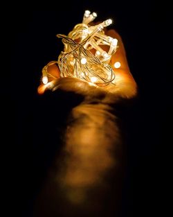 Close-up of illuminated lighting equipment against black background