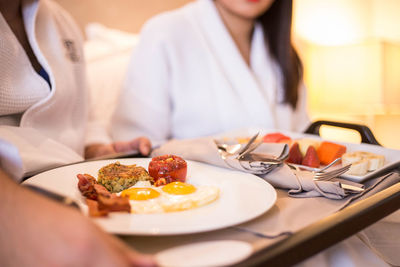 Midsection of woman having breakfast on table