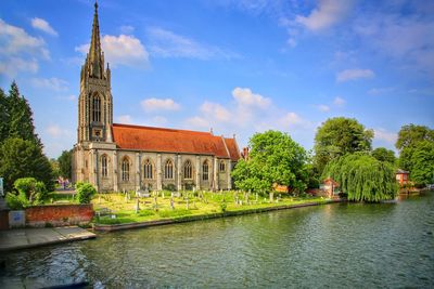 View of building by river against sky