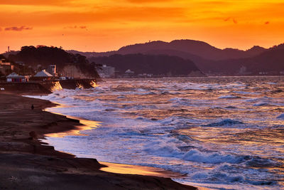 Scenic view of sea against orange sky