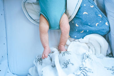 Low section of woman sitting on bed