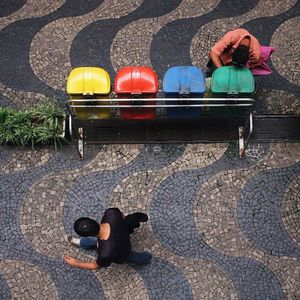 High angle view of man walking on street by garbage bin