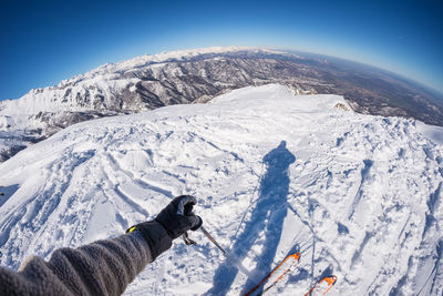 Cropped image of person skiing on snow covered mountain