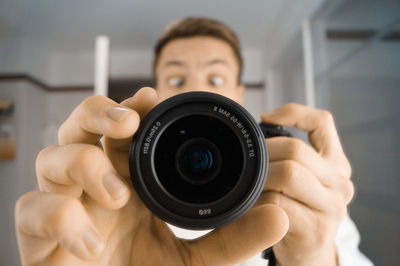 Portrait of surprised man holding camera