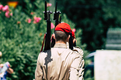 Rear view of man standing against plants