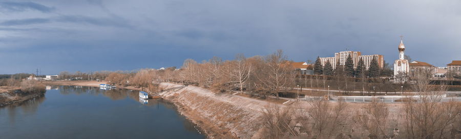 Panoramic view of river by buildings against sky