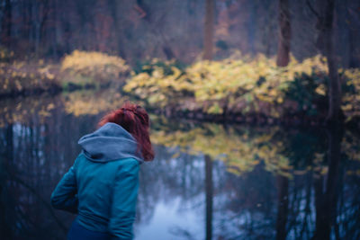 Rear view of woman standing in forest