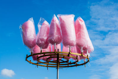 Low angle view of multi colored umbrellas against blue sky