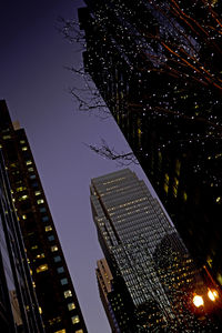 Low angle view of skyscrapers against clear sky at night