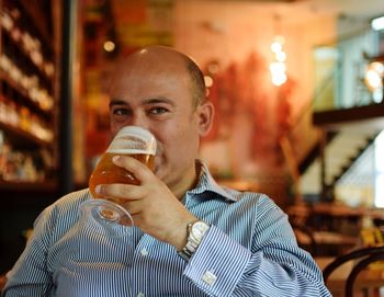 Portrait of man drinking beer in restaurant