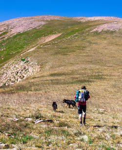 Rear view of people walking on mountain against sky
