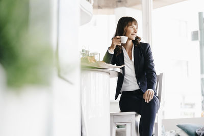 Businesswoman sitting in cafe, drinking coffee