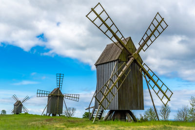 Traditional windmill on field against sky