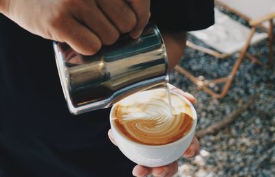 Midsection of man pouring milk