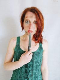 Portrait of beautiful woman standing against white background