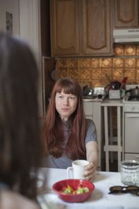 Young woman looking at her boyfriend over coffee