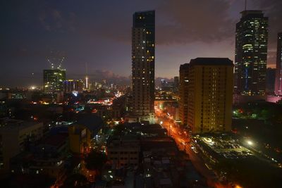 Illuminated buildings in city against sky at night