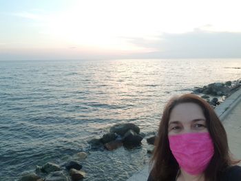 Portrait of young woman in sea against sky