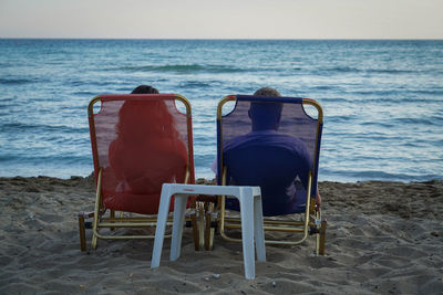 Chair on beach against clear sky