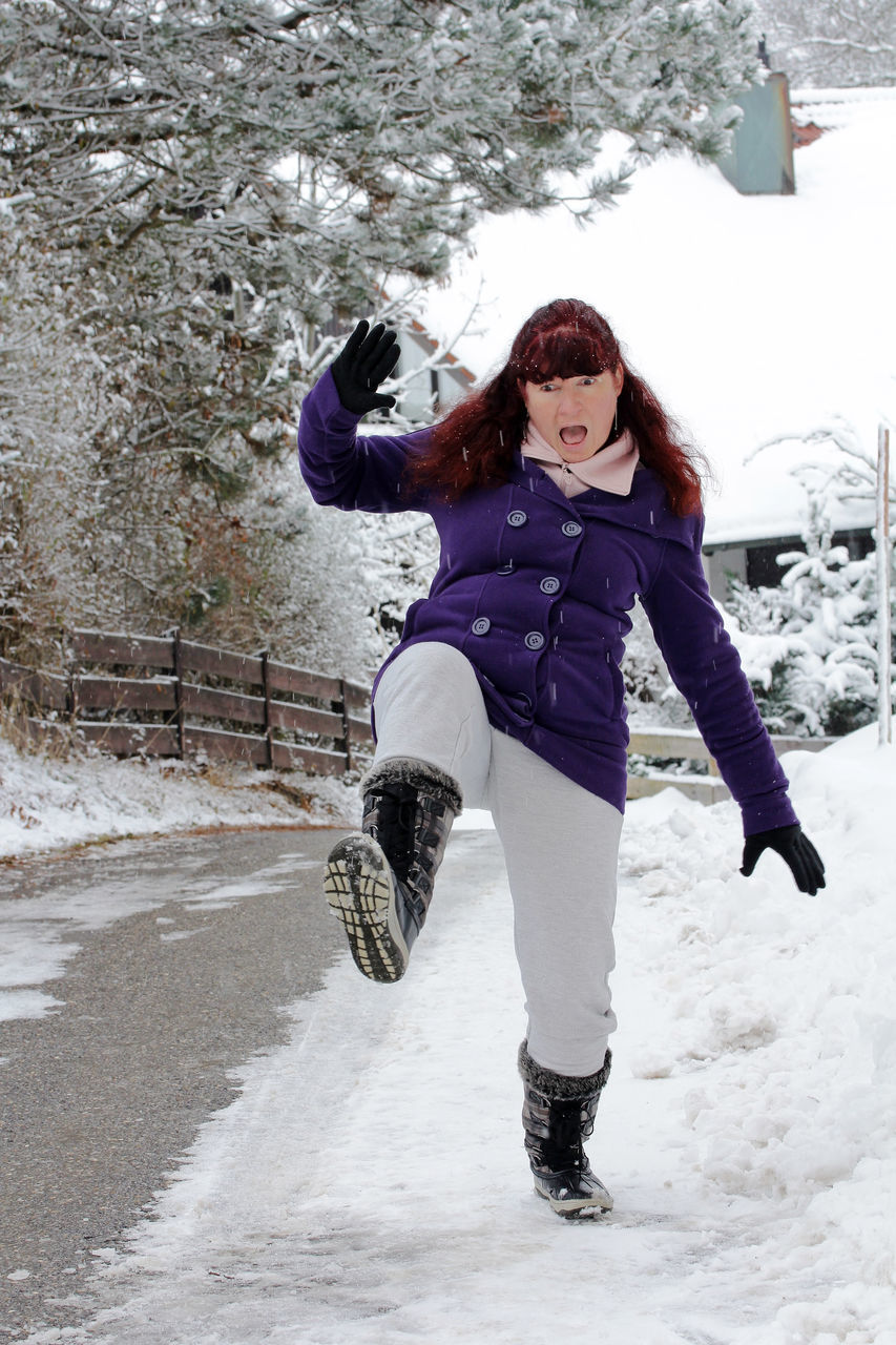 FULL LENGTH PORTRAIT OF WOMAN STANDING ON SNOW COVERED FIELD