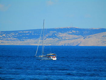 Sailboat sailing on sea against sky