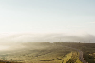 Scenic view of field against sky during foggy weather