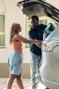 Side view of young woman holding car