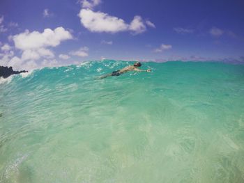 Person swimming in sea against sky