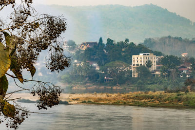Scenic view of lake by buildings against sky