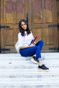 Young woman sitting on book