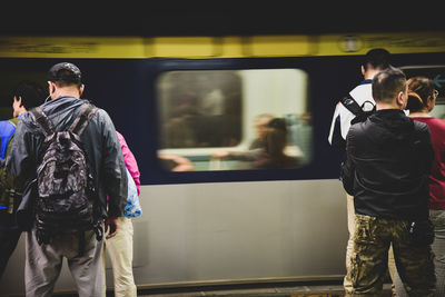 Rear view of people on train at railroad station