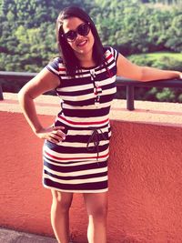 Portrait of young woman wearing sunglasses standing outdoors