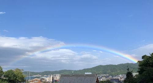 Scenic view of rainbow over town against sky