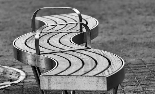 Close-up of empty bench on street