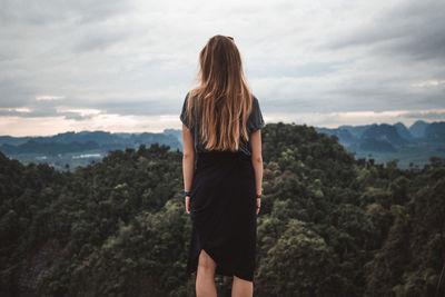 Rear view of woman standing against mountain