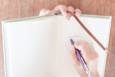 Close-up of hand writing with pen on paper