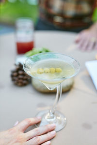 Close-up of hand holding drink on table