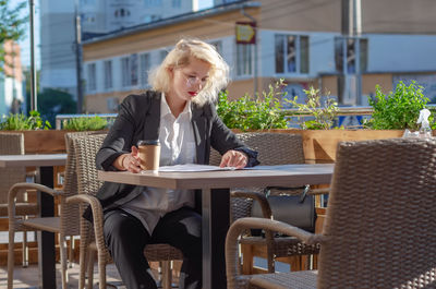 Young woman sitting on table at cafe