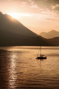 Sailboat sailing on sea against sky during sunset