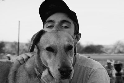 Portrait of man with dog against clear sky