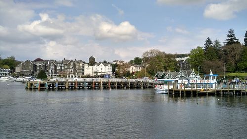 Scenic view of river by buildings against sky